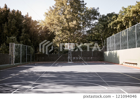 An empty still life of a basketball court on a sunny day with white marking with a hoop and net. A sports ground or court on a club venue for active practices training and outdoor leisure activities 121094046