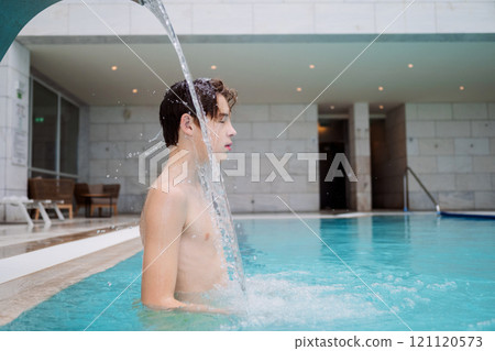 Teen boy relaxing in spa pool 121120573