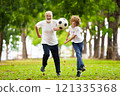 Grandfather and kids play football in summer park 121335368