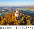 The elegant Humprecht chateau stands atop a hill, surrounded by vibrant autumn foliage. The soft glow of sunrise illuminates the landscape, creating a picturesque atmosphere in Bohemian Paradise. 122493773