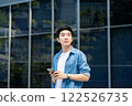 Portrait of handsome Asian student using smartphone 122526735