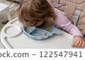 A playful toddler exploring food in a creative and funny way during mealtime. 122547941