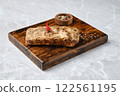 Roasted pork ribs on a rustic wooden board, with a small bowl of mixed spices 122561195