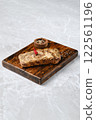 Grilled pork ribs on a rustic wooden board, with a small bowl of mixed spices 122561196