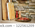 Chopped bacon served on a rustic plate in a cozy kitchen setting with wooden boards 122561209