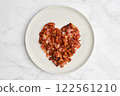 Heart-shaped bacon arranged on a plate showcases love for breakfast food art 122561210