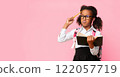 African American Schoolgirl Thinking On Task During Quarantine Distant Learning Holding Book Standing Over Yellow Studio Background. Panorama, Copy Space 122057719