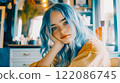 A beautiful blue-eyed teenage girl with blue hair sits with her hand propping her head up in beauty salon. Unusual appearance. Young woman indoors. 122086745