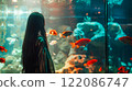 Asian young woman with dark hair female portrait in profile looking at the large aquarium with red fish. Leisure and entertainment. A girl in the zoo. 122086747