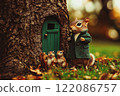 Happy brave bold chipmunk squirrel with small baby squirrels in green wool coat standing on his porch near green door in tree trunk. Rodent family. 122086757