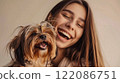 Beautiful super model girl hugs and cuddles her beloved Yorkshire Terrier dog. Woman and dog laugh together. Human-animal friendship. Happy together.  122086751