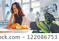 Beautiful young woman in a modern office sitting, a basket of fresh fruit on the table. Office workers talking. Green plants indoors. Anime style girl 122086753