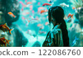 Asian young woman with dark hair female portrait in profile looking at the large aquarium with red fish. Leisure and entertainment. A girl in the zoo. 122086760