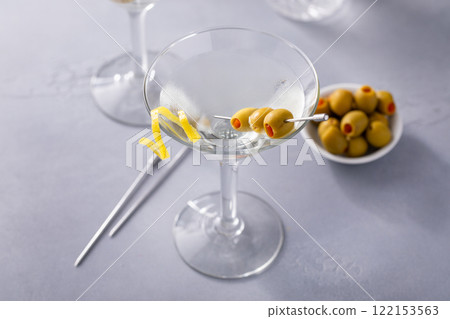 Lemon drop martini cocktail with olives and a lemon twist 122153563