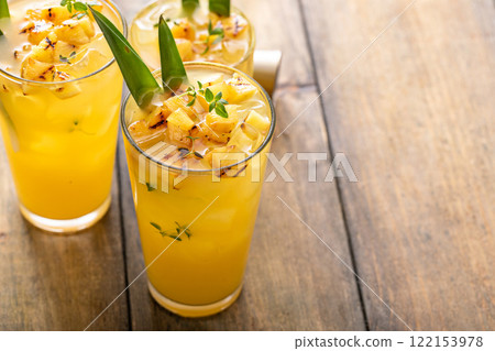 Grilled pineapple cocktail or mocktail garnished with pineapple leaves 122153978