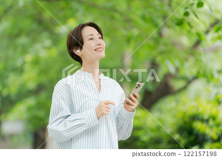 A woman listening to music in the fresh green 122157198