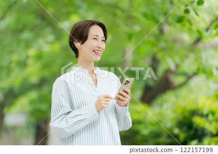 A woman listening to music in the fresh green 122157199