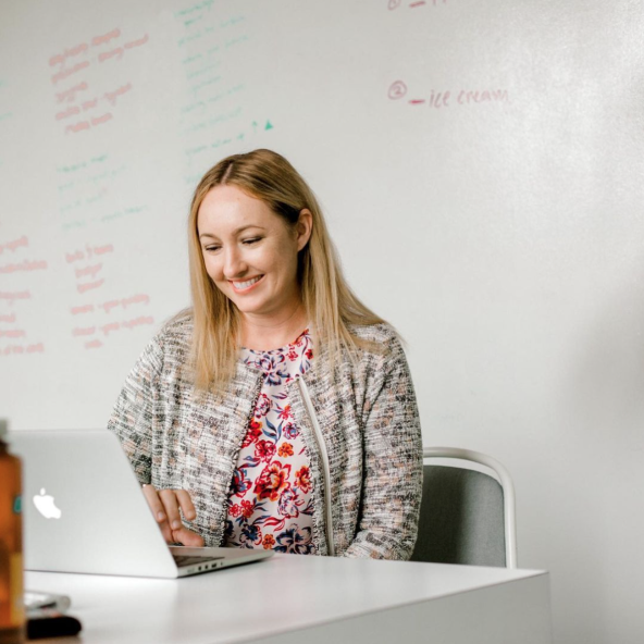 Photo of Focus Lab team member, Amy, working from her laptop in a conference room.