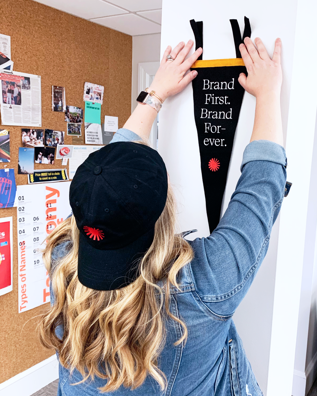 Photo of Focus Lab team member, Charisse, pinning something onto a cork board wall.