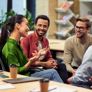 A diverse group of colleagues smiling while sitting together and having a discussion.