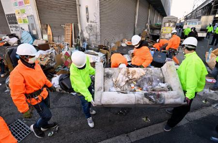 　「あいりん総合センター」での野宿者らに対する強制執行が着手され、荷物を撤去する作業員ら＝１日午前、大阪市西成区のあいりん地区