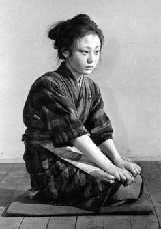 an old photo of a woman sitting on the floor