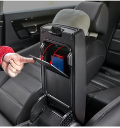 a person in a car pointing at the back seat with their hand on the armrest