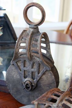 an old metal object sitting on top of a wooden table