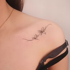 the back of a woman's shoulder with a vine tattoo on her left shoulder