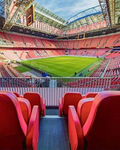 an empty soccer stadium with red seats