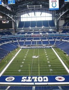 an empty stadium filled with lots of blue seats and white letters on the sidelines