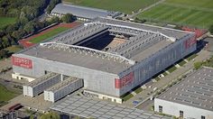 an aerial view of a large building in the middle of a field with lots of grass