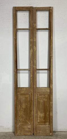 an old wooden double door with two glass panels on the front and back doors, against a white wall