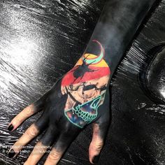 a person's hand with a tattoo on it that has an image of a demon