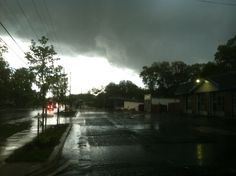 the sun shines brightly through dark clouds over an empty street with no cars on it