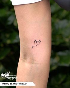 a woman's arm with a small heart tattoo on the left side of her arm