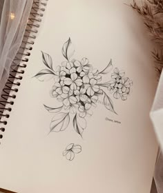 a drawing of some flowers on a sheet of paper next to a pen and pencil