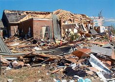 a pile of rubble sitting on top of a field next to a building with a fire hydrant