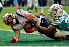 a football player is diving for the ball