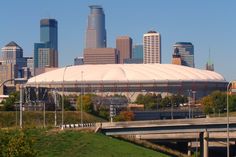 the city skyline is seen in this view from across the river, with an olympic stadium on the other side