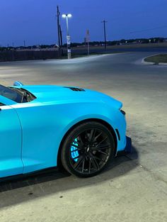 a blue sports car is parked on the street