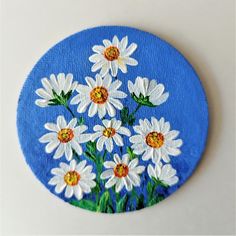 a blue circle with white daisies painted on it