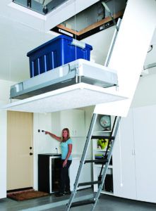 a woman standing on top of a ladder in a room with white walls and floors