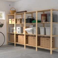 a bike is parked in front of a wooden shelving unit with bins and baskets