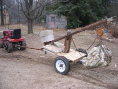 an old wooden wagon is being pulled by a lawn mower