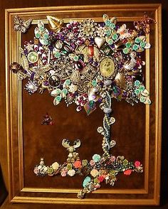 a wooden frame holding a bunch of different types of buttons and brooches on it