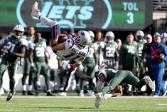 a football player diving into the air to catch a ball