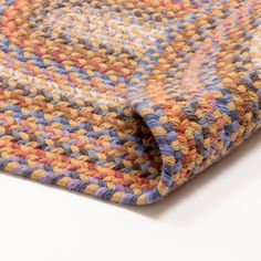 a close up view of a multicolored knitted blanket on a white surface