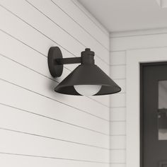 an outdoor wall light on the side of a house with white siding and black door