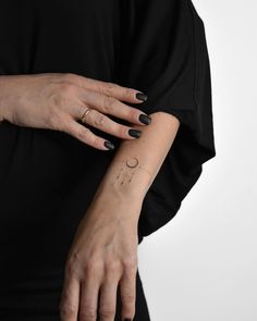 a woman's arm with a small tattoo on it